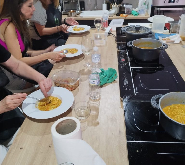 Talleres de cocina en MAdrid grupo alfoli Grupo de personas cocinando y preparando ensaladas en una cocina luminosa.